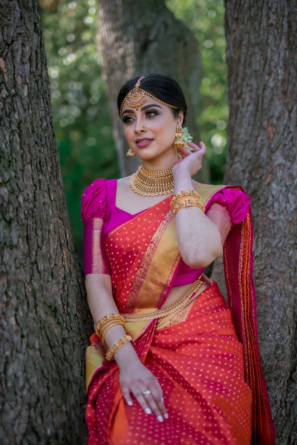 Woman in a pink and gold saree outdoors